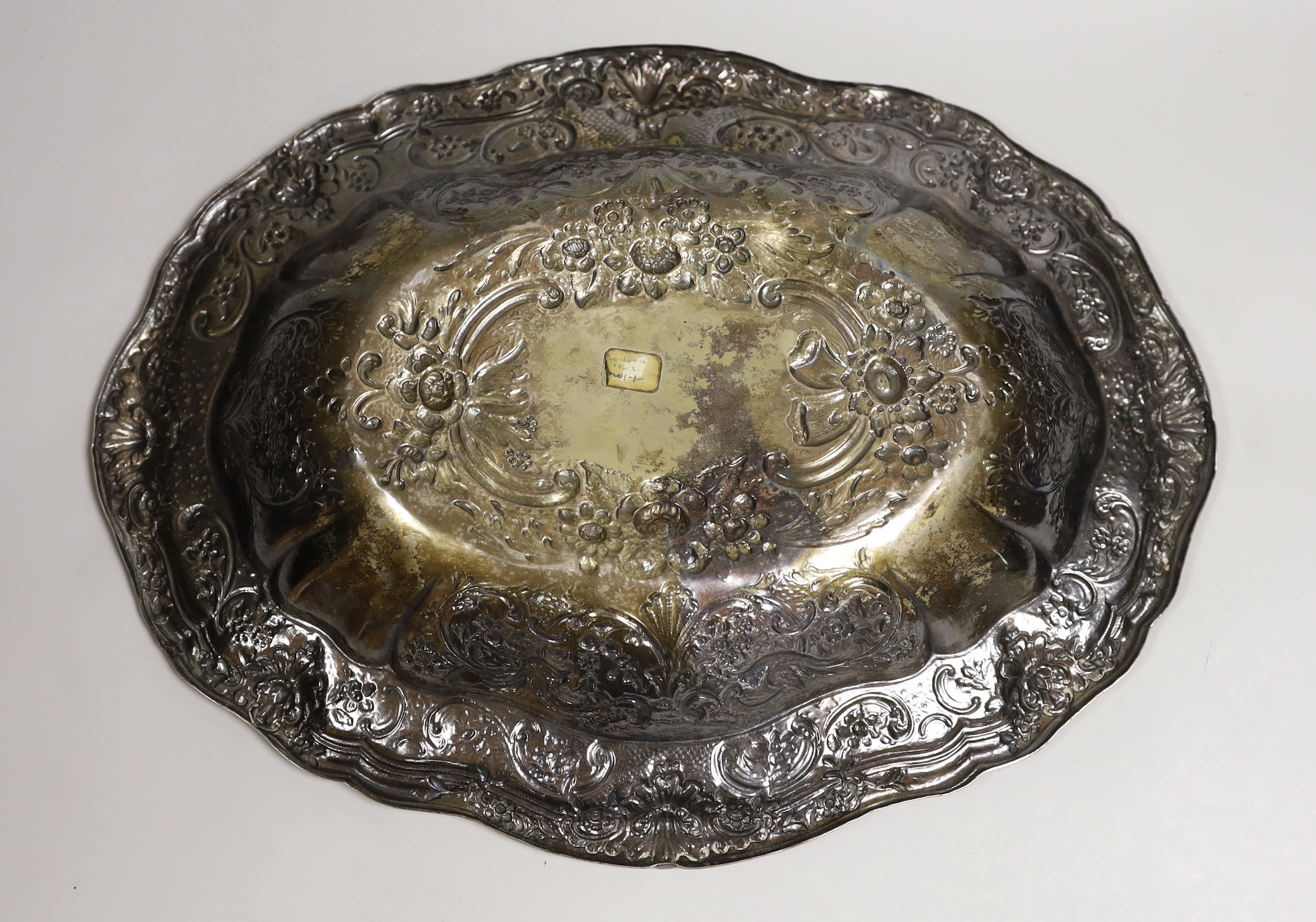 A large late 19th/early 20th century continental white metal oval bowl, embossed with birds, scrolls and flowers, 45.8cm, 40oz.